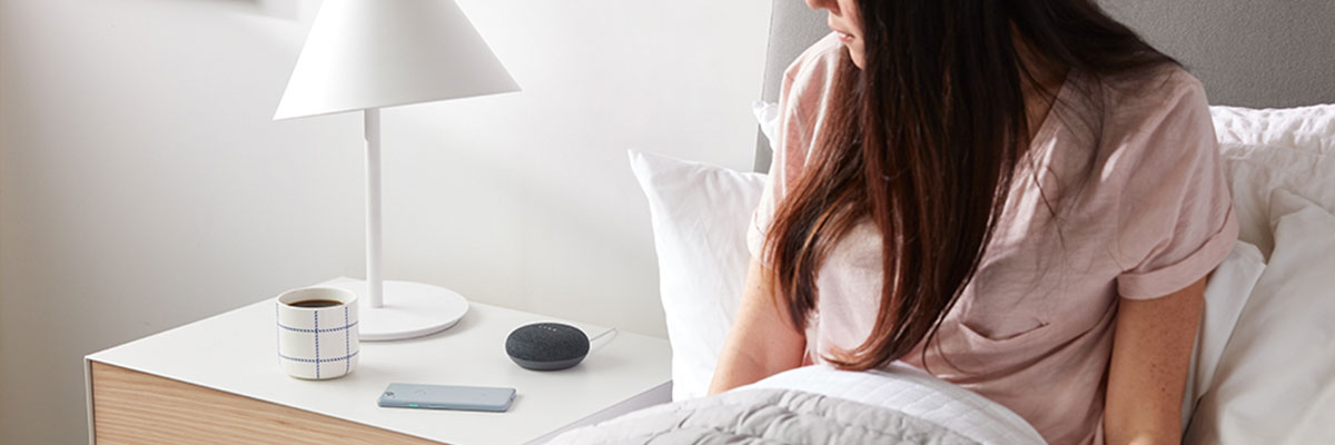 google-home-mini-on-bedside-table-playing-music